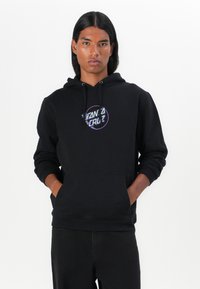 Felpa nera con cappuccio e tasca frontale, caratterizzata da un colorato logo "Santa Cruz" sul petto. Design casual con cappuccio regolabile tramite cordino.