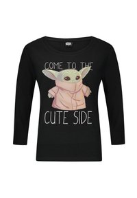 T-shirt a maniche lunghe nera con una grafica di un personaggio in un accappatoio rosa con grandi orecchie. Il testo recita "VIENI DALLA PARTE CARINA."