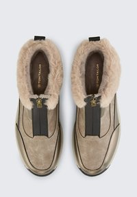 Bruine suede enkellaarzen met nepleren rand, zwarte elastische zijpanelen, gouden ritsaccent en een ronde neusontwerp.