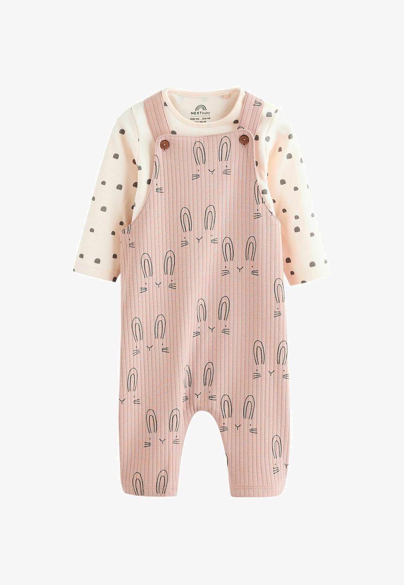 Rosa gestreifte Latzhose mit Hasenmotiv, darunter ein langärmliges Oberteil mit leichten gepunkteten Mustern. Knöpfe an den Trägern.