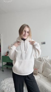 Kremveida mētelis ar augstu apkakli, priekšējo rāvējslēdzēju un ribotām piedurknēm. Apvienots ar melniem biksēm uz gaiša fona.