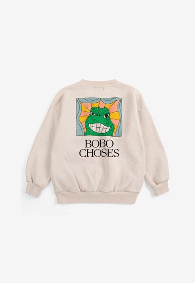 Sweat-shirt beige avec une grenouille dessin animé colorée souriante dans un cadre carré et texte "BOBO CHOSES" sous le design dans le dos.