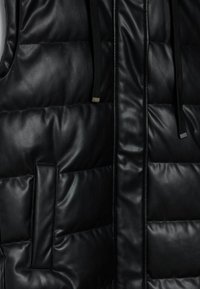 Schwarze gepolsterte Weste aus glänzendem, lederähnlichem Material, mit zwei Taschen, einem Reißverschluss und verstellbaren Kordelzügen an der Kapuze.
