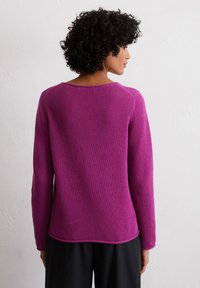 Fuchsia gestrickter Pullover mit strukturiertem Muster, Rundhalsausschnitt und langen Ärmeln, mit einem leicht gebogenen Saum und lockerer Passform.