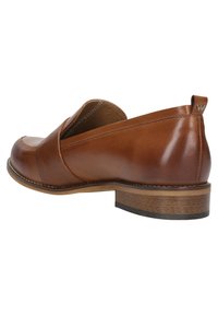 Bruine leren instaplaars met een ronde neus, een lichte hak en stiksels langs de rand. Inclusief een logo-accent op de hak.