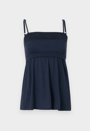 Navy blue sleeveless top with adjustable spaghetti straps, smocked waistband, and lace detail along the straight neckline.