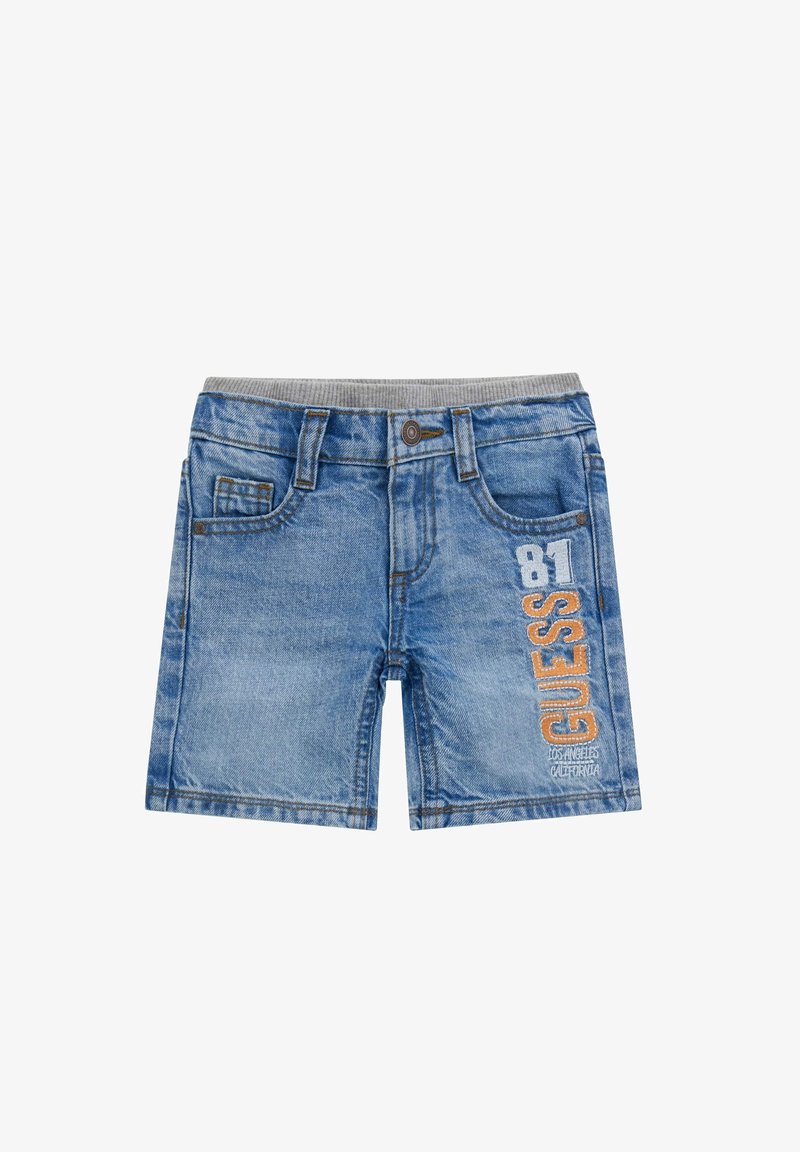 Shorts en denim de couleur bleu clair, avec une ceinture élastique grise, des poches avant et des détails brodés "GUESS" et "81" sur le côté.
