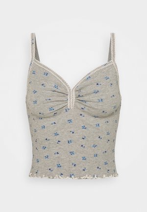 Top corto gris con textura acanalada, tirantes finos, pequeño estampado floral azul, bordes con ondas y escote en forma de V fruncido.