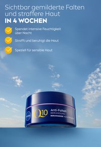 Purple jar with a blue lid, labeled "Q10 Anti-Falten," designed for nighttime use. Smooth texture, modern design, and clear brand logo.