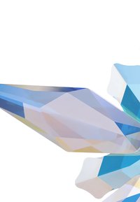 Modrá kryštálová socha s ostrými, facetovými hranami; rôzne odtiene modrej a svetla, ktoré sa odrážajú na hladkých povrchoch; viditeľné priesvitné časti.