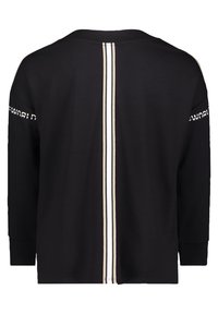 Chemise noire à manches longues avec des rayures verticales blanches et beiges au centre du dos et un texte blanc partiellement visible sur le haut des manches.