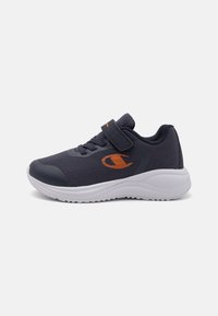 Sport sko i mørk marineblåt stoff, med polstret krage, borrelåslukking, gummisåle og oransje logodetalj på siden.