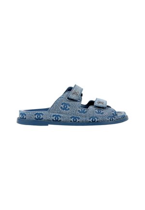 Sandale en denim bleu avec deux brides ajustables présentant un motif répété du logo double-C et une semelle plate.