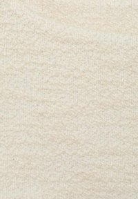 Tissu en crème doux et texturé avec une surface douillette et floue. Le matériau semble épais, avec un léger éclat et une légère irrégularité à travers tout.