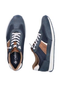 Chaussures de sport bleu marine avec des lacets blancs, des accents latéraux marron, des panneaux en mesh, un intérieur beige rembourré et des semelles blanches.