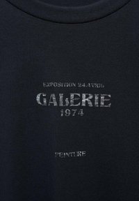 Dark navy cotton t-shirt featuring gray printed text: "GALERIE 1974" and "EXPOTITION 24 AVRIL," with a smooth texture and crew neck design.