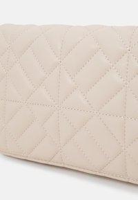 Quiltet lys beige læderpung med hævede diamantmønstre, der har synlige sømme og en glat overflade. Kompakt rektangulær form.