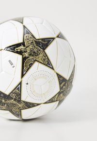 Balle de soccer blanche avec un design étoilé noir et or, comportant des illustrations d'animaux et des motifs célestes. Taille 5 indiquée.