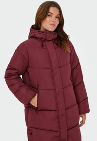 Burgundy pufferjacka med huva, med en zippered ficka, quiltad textur och justerbara dragsnören vid halsen.