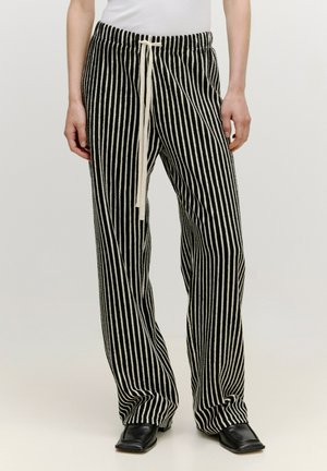 Gestreifte Schwarz-Weiß-Hose mit einem Kordelzugbund, lockerer Passform und weicher Textur, mit vertikalen Linien und taillierten Kanten.