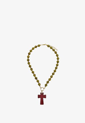 Naszyjnik z zielonymi koralikami i czerwonym wisiorkiem w kształcie krzyża, z złotymi ogniwami łańcuszka i regulowanym zapięciem.