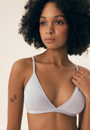 Helles grau geripptes Dreieck-Bralette mit dünnen Trägern und flachen Nähten, das eine glatte Textur und ein minimales Design zeigt.