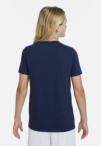 Námořnická modrá krátká rukávová tričko s kulatým výstřihem, vyrobené z měkké, hladké tkaniny. Má minimalistický design na zádech bez ozdob.