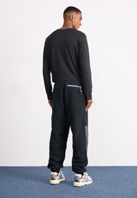 The North Face M RETRO DENALI PANT - Tracksuit bottoms - black/moonstone grey
