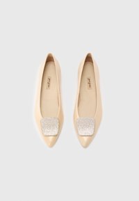 Ballerines beige à bout pointu avec un détail carré texturé argenté sur le dessus. Tige en cuir lisse avec une finition mate. Design minimaliste.