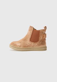 Botines de bronce con glitter, paneles laterales elásticos, bordes ondulados y una pequeña lengüeta en la parte trasera. Superficie texturizada y suela de goma beige.