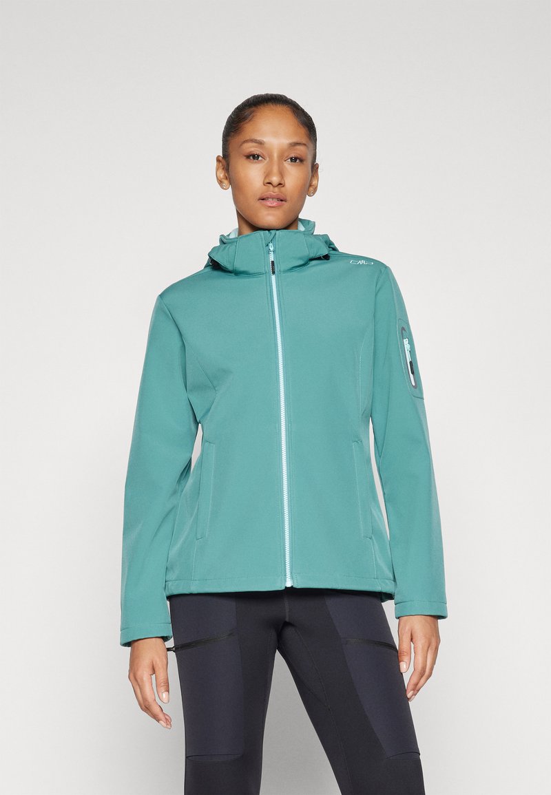 Jachetă din material soft-shell de culoare teal, cu un design ajustat, închidere cu fermoar și glugă. Include buzunare laterale și un buzunar pe braț cu fermoar.