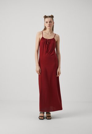 Rochie maxi roșie cu decolteu plisat și detaliu cu nod în față. Fabricată dintr-un material moale și ușor. Are bretele subțiri.