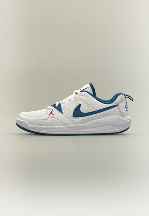 Λευκό και μπλε χαμηλό sneaker Nike Air Jordan με κόκκινο λογότυπο Jumpman και λεπτομέρειες από δίχτυ και δέρμα σε ουδέτερο φόντο.