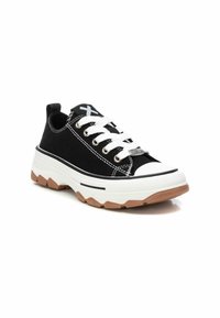 Sneaker nera in tela con lacci bianchi, suola intermedia bianca spessa e suola in gomma testurizzata. Presenta un design a contrasto bianco e nero.