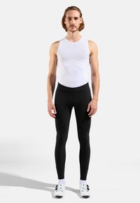 Black cycling tights and a white sleeveless top, featuring a fitted design, smooth texture, and contrasting seams. White athletic shoes with black accents.
