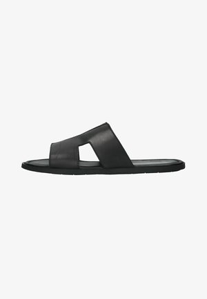 Black leather slide sandal with an open toe and two cross straps, featuring a cut-out design. Flexible rubber sole. Smooth texture.
