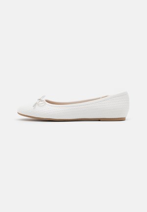 White ballerina flat shoe with woven texture, a small bow accent at the front, and a low, brown sole. Smooth inner lining.