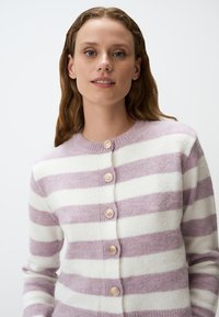 Cardigan con bottoni in maglia morbida, caratterizzato da strisce lavanda e bianche. Collo rotondo con bottoni texturizzati e polsini a costine.