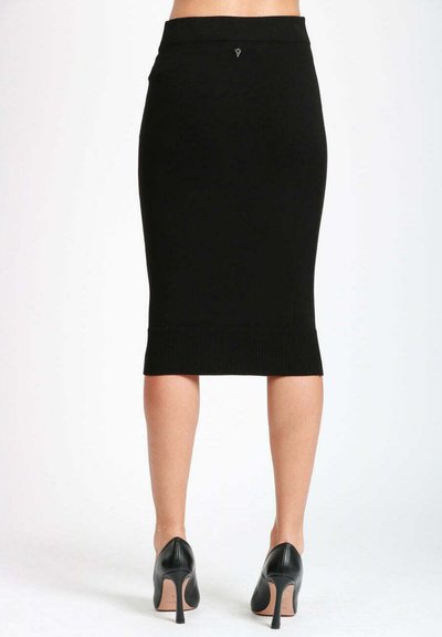 Zwarte geribbelde kokerrok met een slim fit, hoge taille en textuur aan de onderrand, gecombineerd met zwarte hoge hakken, gezien van achteren.