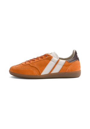 Pomarańczowy zamszowy sneaker z białymi paskami, brązową zakładką na pięcie i gumową podeszwą, pokazany z profilu na białym tle.
