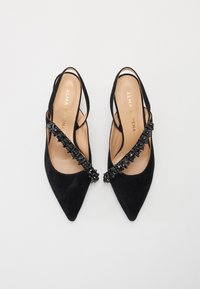 Sorte semskede slingback-sko har en spiss tå og en dekorativ krystallakzent langs reimen. Myk skinnfôr er synlig inni.