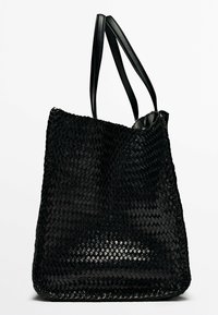 Sac fourre-tout noir en tressage avec deux poignées en cuir noir, présentant une forme structurée et une surface texturée. Fini mat, sans matériel visible.