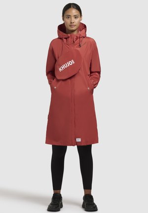 Rode waterdichte parka met capuchon, voorzien van zijzakken en een rits aan de voorkant. Inclusief een afneembare tas met logo-accent. Slanke pasvorm.