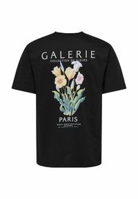 Zwarte katoenen t-shirt met een bloemig graphic design met gele, roze en blauwe bloemen en de tekst "GALERIE COLLECTION DE FLEURS".