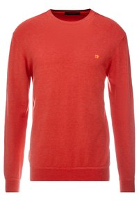 Pull tricot rouge avec un col rond, des manches longues et des poignets côtelés. Présente un petit logo jaune sur la poitrine. Texture douce.