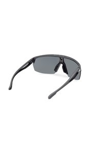 Gafas de sol negras con un diseño elegante, lentes rectangulares y patillas de goma. Cuenta con lentes grises espejados y una montura ligera.