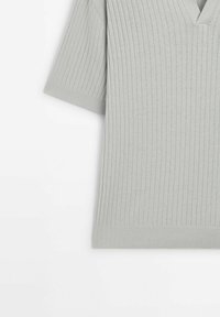 Haut en maille côtelée gris clair à manches courtes avec un décolleté en V, présenté à plat sur fond blanc.