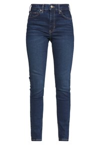 Vaqueros de mezclilla azul oscuro con ajuste slim, cintura alta, cremallera y diseño clásico de cinco bolsillos. Presentan costuras en contraste y un botón resistente.