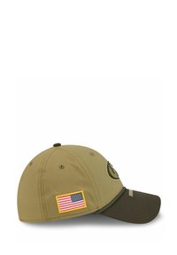 Khakifarbene Baseballmütze mit einem gestickten Logo, brauem Schirm und einem Seitenpatch mit der amerikanischen Flagge. Glattes Gewebe, geschwungene Form.