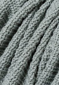 Hellgrauer Strickstoff mit einer strukturierten Rippenmusterung, ausgestattet mit weichen und dicken Garnsträngen. Ideal für warme Bekleidung oder Accessoires.